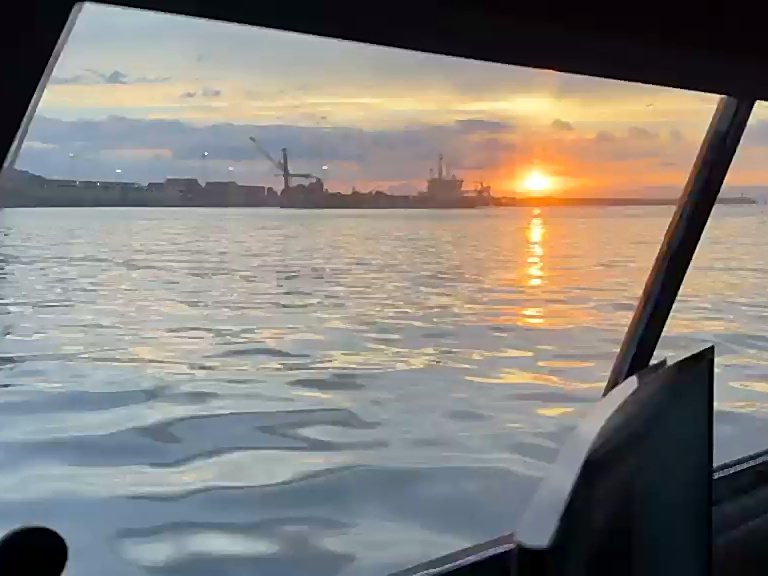 Amanecer sobre el puerto visto desde la cabina de la embarcación de levantamiento